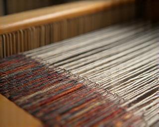 Close-up of a traditional Japanese weaving loom in action with intricate threads